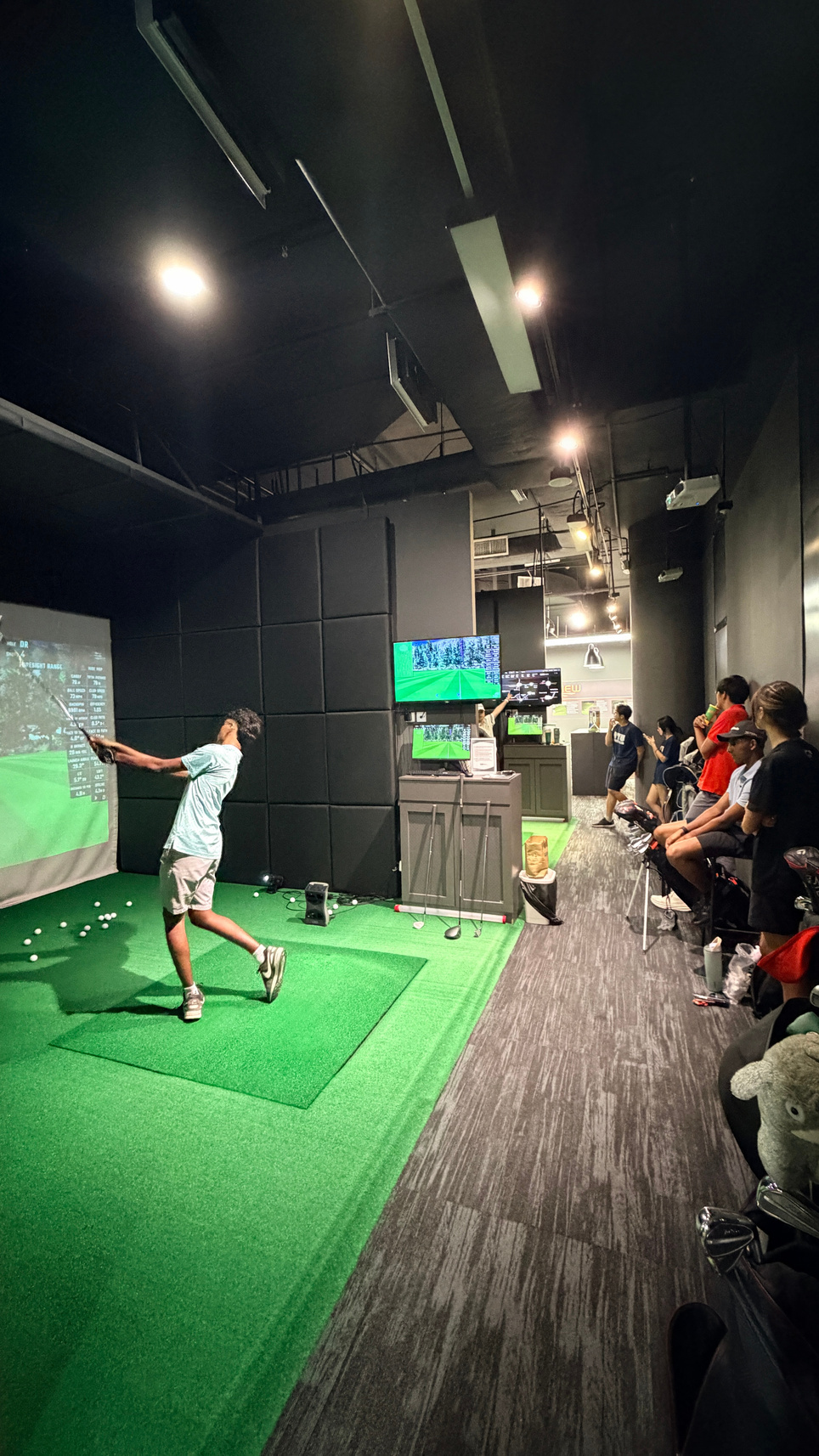 A Lip Golf clinic with guests watching a swing demonstration