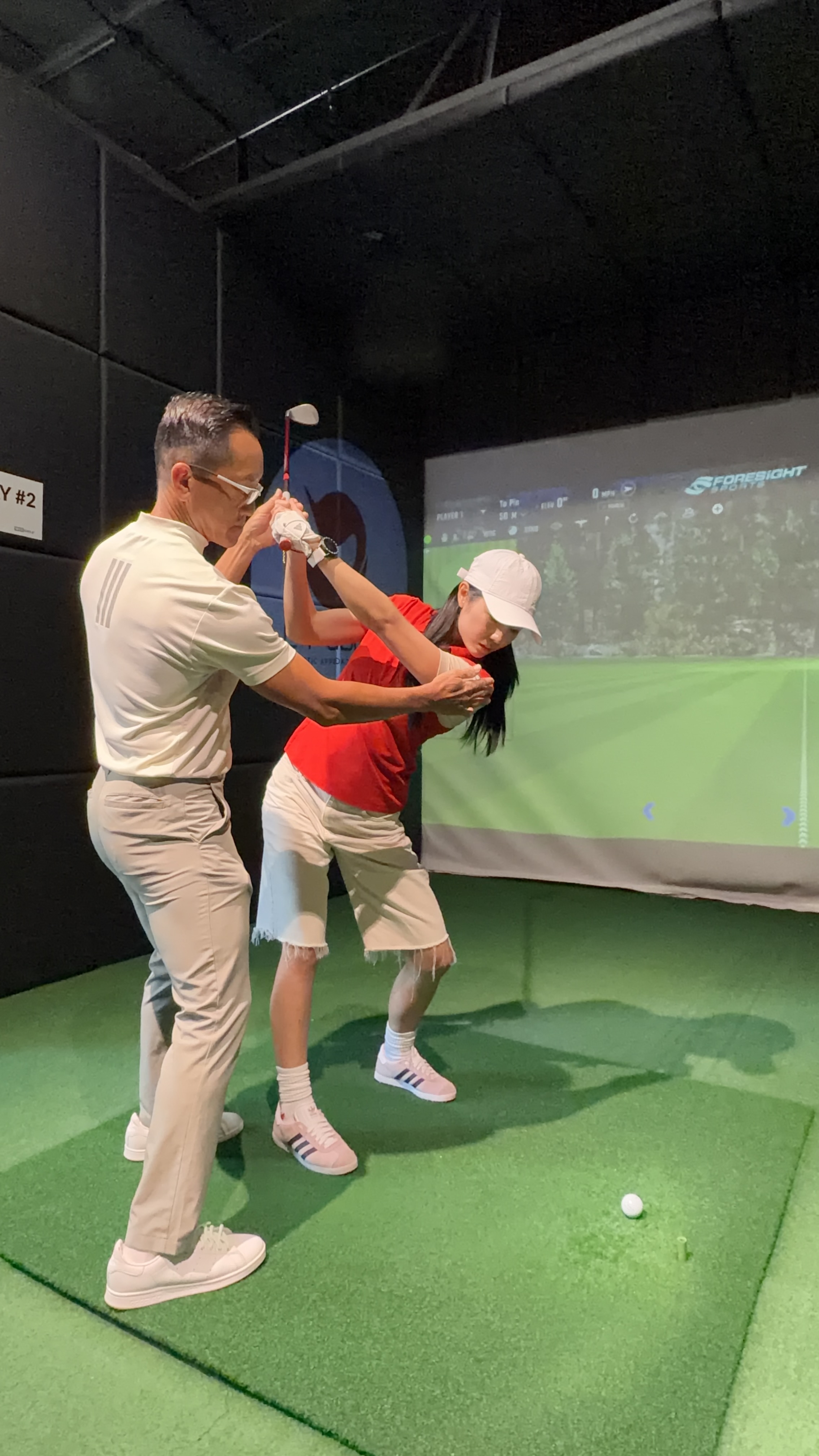 A Lip Golf coach helping a golfer develop her swing
